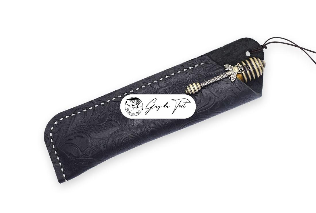 Una funda para bolígrafo de cuero de alta calidad con un detallado motivo floral grabado en su superficie.