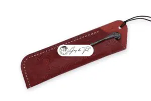 A high-quality leather pen sleeve with a detailed flower pattern embossed on its surface.