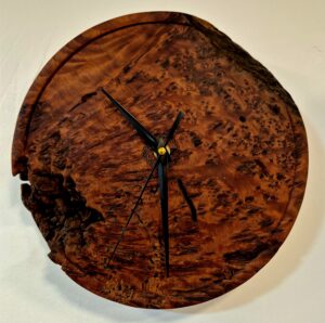 Horloge murale en loupe de Totara tournée par Guy du Toit, montrant des figurations rares en œil d'oiseau et un contraste extérieur non fini et usé par les intempéries.