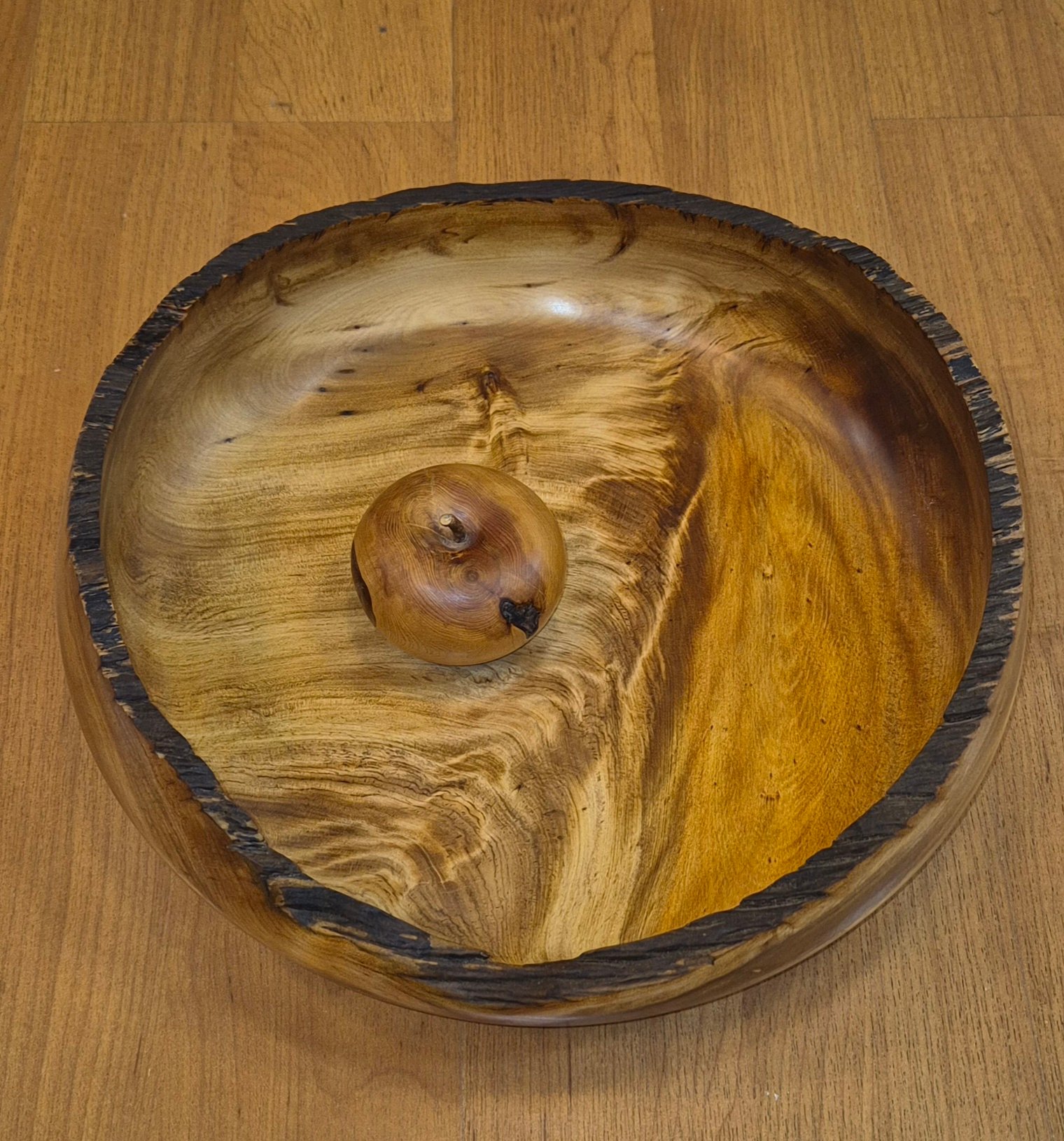 Ancient swamp kauri bowl with charred rim handcrafted by Guy du Toit with apple for scale