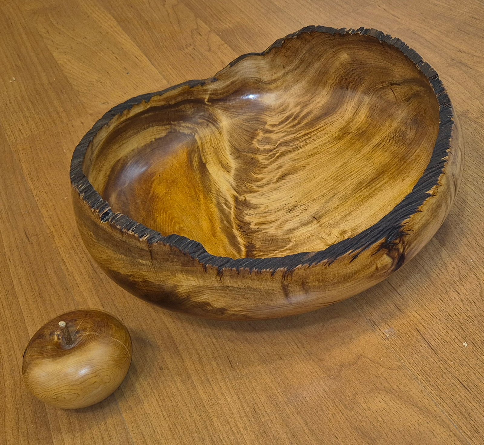Ancient swamp kauri bowl with charred rim handcrafted by Guy du Toit with apple for scale